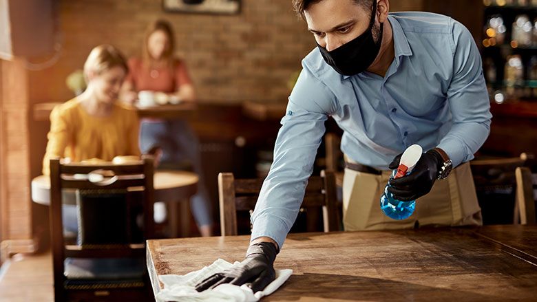 Restaurant worker wiping tabletop