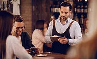 Server taking food orders from restaurant customers