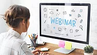 woman in front of a desktop monitor that says WEBINAR