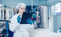 Food Safety Auditor Conducting Facility Inspection Food safety auditor reviewing inspection records in a food processing facility.