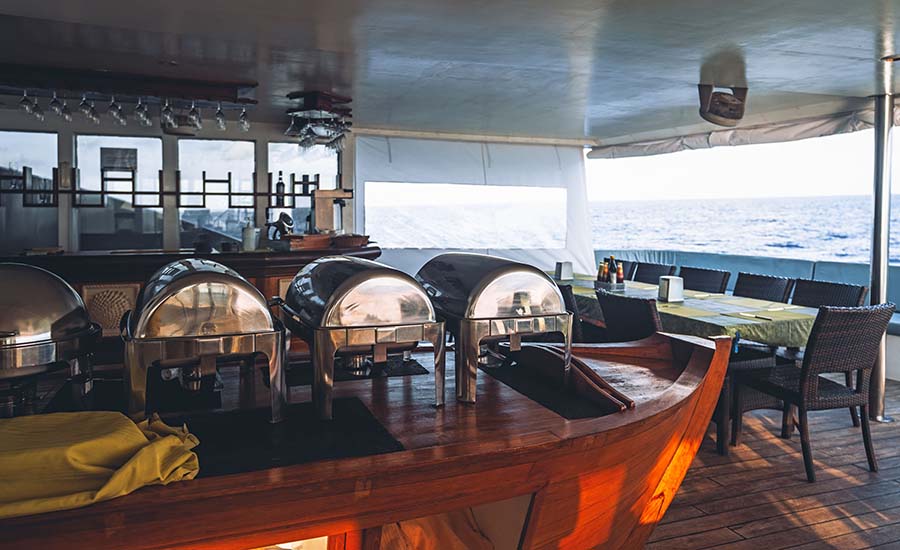 Breakfast spread on a table overlooking the ocean from a cruise ship.