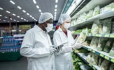 epidemiologists or scientists in white lab coats and masks and hairnets in a grocery store investigating lettuce
