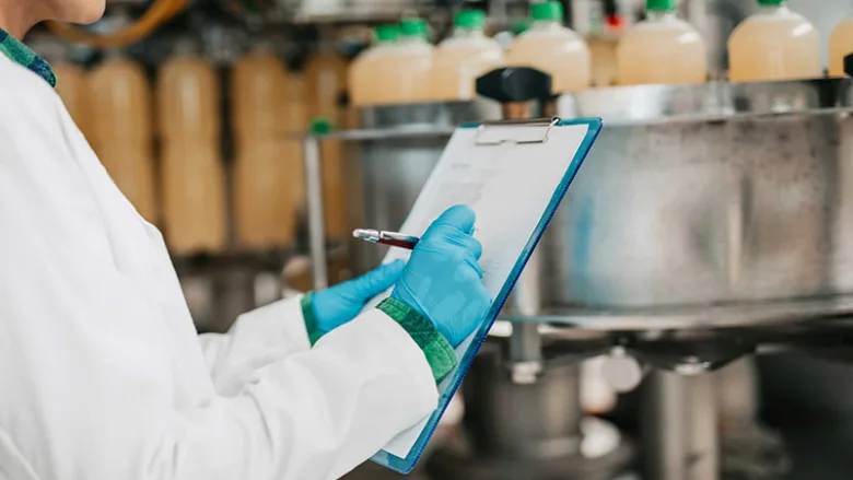 checking a list on clipboard in food manufacturing facility bottling plant