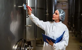 Checking the temperature on a steel tank in a winery room