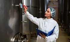 Checking the temperature on a steel tank in a winery room