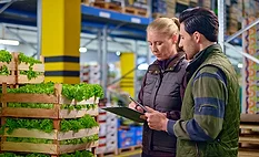lettuce warehouse traceability two people working in warehouse next to pallets of lettuce looking at documents