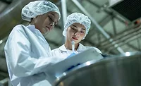 employees checking clipboard in food manufacturing facility employees checking clipboard in food manufacturing facility