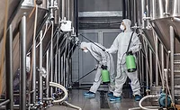 workers in protective gear performing industrial cleaning and disinfection workers in protective gear performing industrial cleaning and disinfection