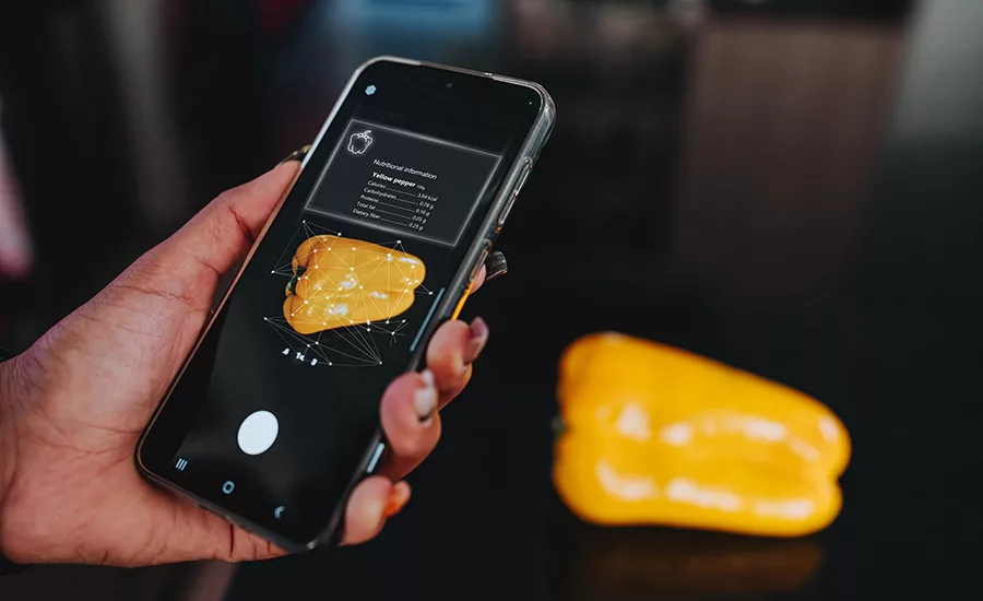 a smartphone displaying nutritional information overlaid on a bell pepper