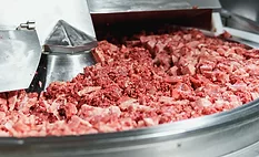 ground meat being processed by a meat grinder