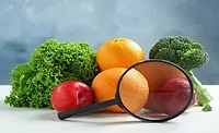 Fresh fruits, vegetables and magnifying glass on white table against light blue background. Food poisoning concept