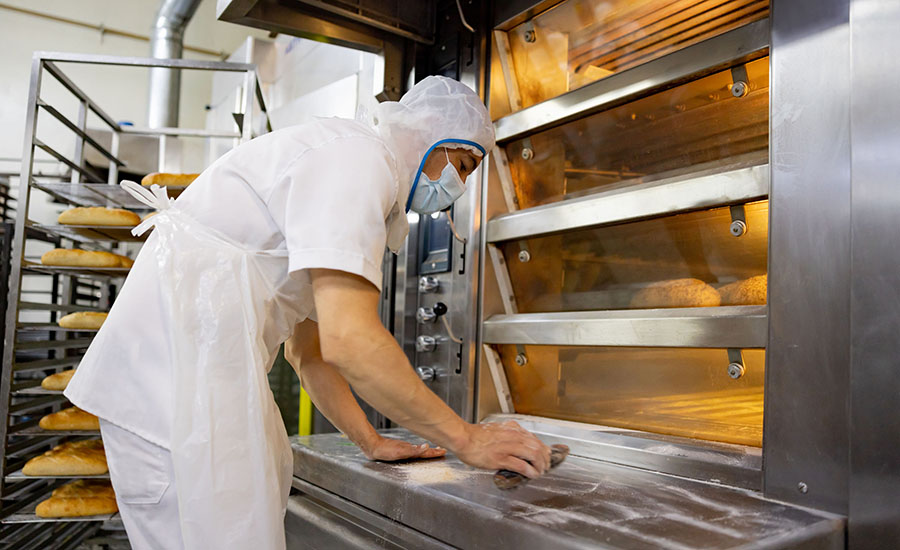 man cleaning oven