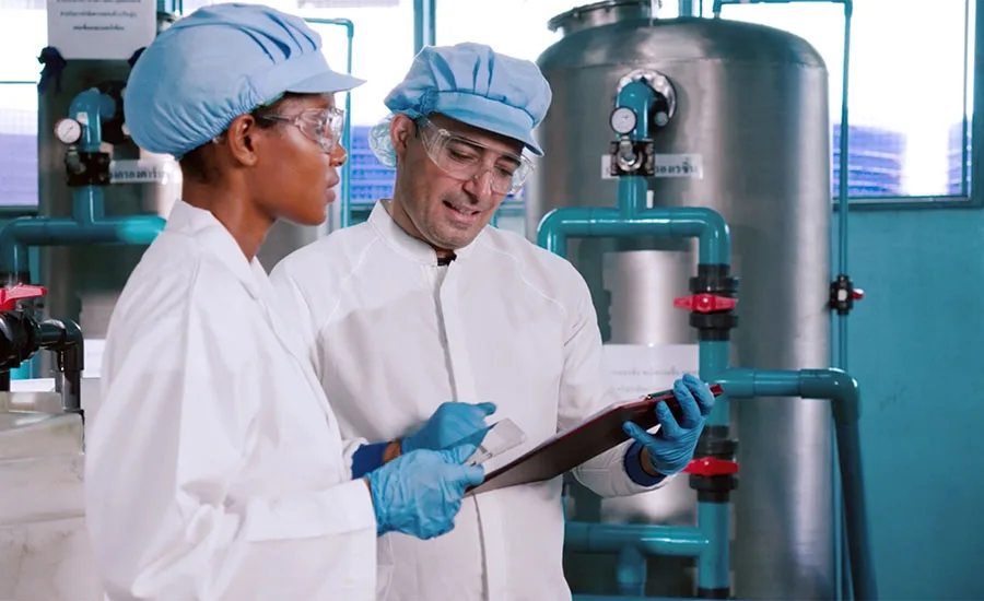 This image shows two quality control specialists in protective gear This image shows two quality control specialists in protective gear