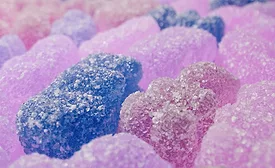 This image shows a close-up texture background of colorful jelly gummy bear candies. 