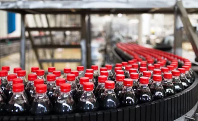 The image displays a bottling plant production line, commonly used in the beverage industry for filling and packaging soft drinks. 