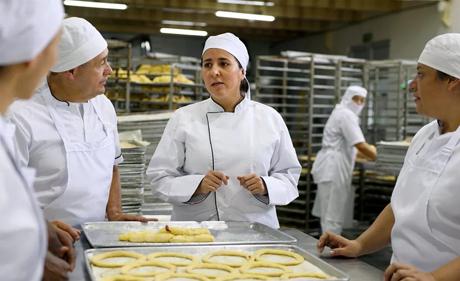bakers in a commercial kitchen likely preparing traditional pastries