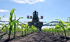 an agricultural sprayer mounted on a tractor