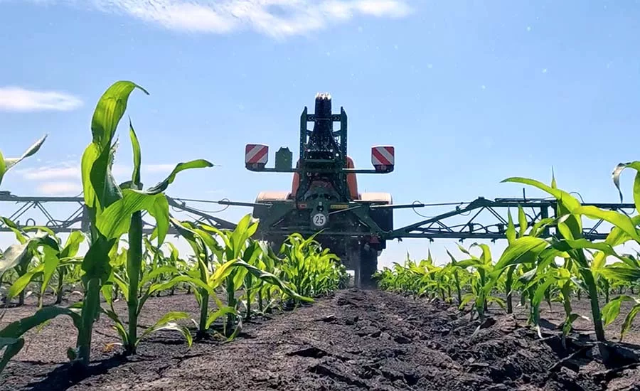 an agricultural sprayer mounted on a tractor