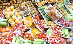 The image shows a variety of fresh produce packaged in plastic trays and wrap.
