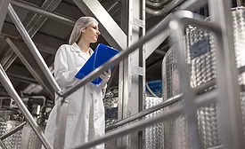 a stock photo depicting a person working in a food processing or manufacturing facility