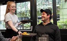 a server providing dining service to a customer a server providing dining service to a customer