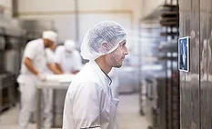 Worker using facial recognition at a food manufacturing facility