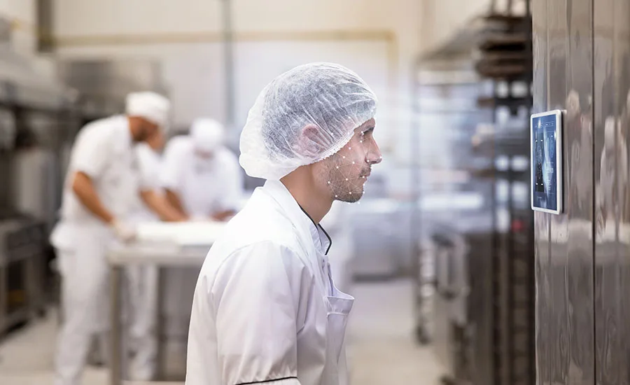 Worker using facial recognition at a food manufacturing facility Worker using facial recognition at a food manufacturing facility