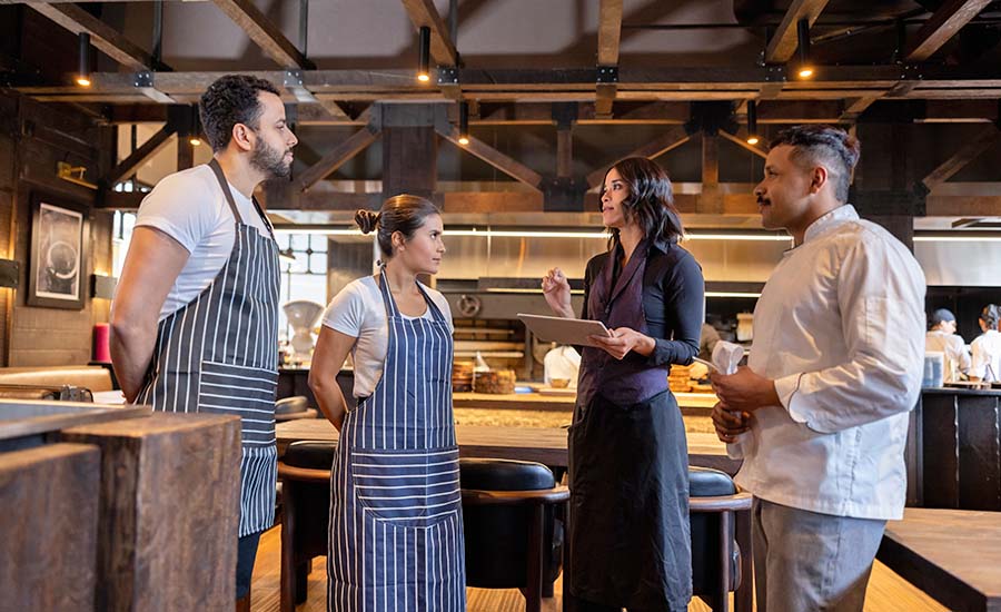 a restaurant manager or owner talking with a team of staff members
