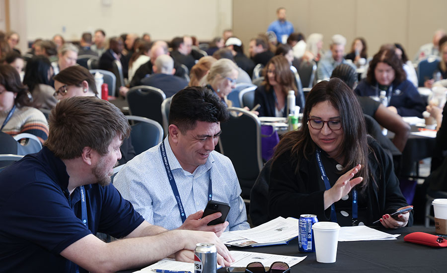 a group of people sitting at tables during a conference or business workshop