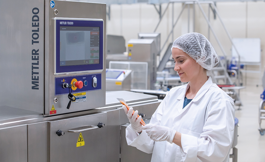 an industrial quality inspection workstation featuring a Mettler Toledo X-ray or product inspection system in a cleanroom or food processing environment