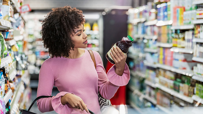 woman inspecting food label in grocery store
