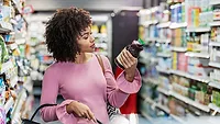 woman inspecting food label in grocery store