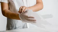 person putting on plastic gloves