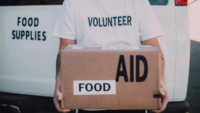 volunteer holding food donations box