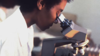 woman looking through microscope CDC via unsplash