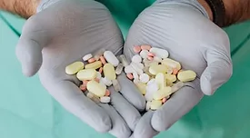 doctor's gloved hands holding antibiotics