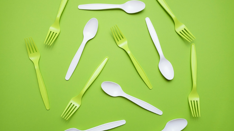 green and white plastic forks on a green background