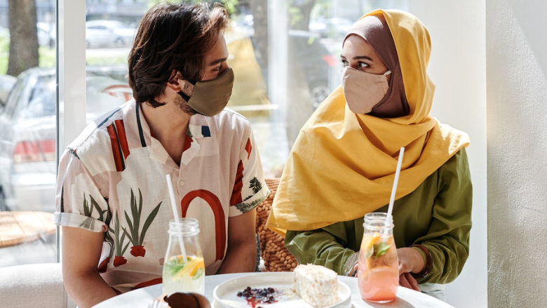 people eating at a cafe with masks on