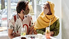 people eating at a cafe with masks on
