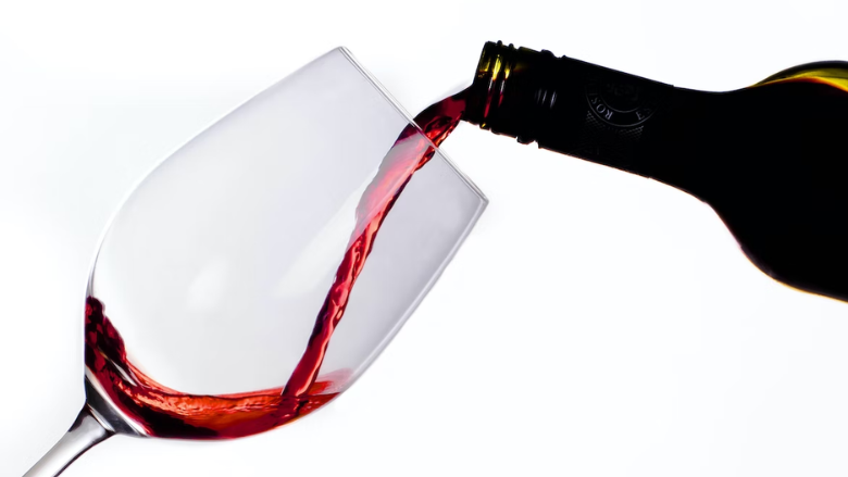 red wine being poured white background.png