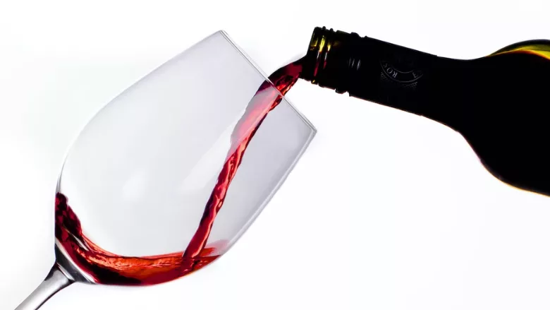 red wine being poured against white background