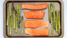 raw salmon fillet and asparagus on baking tray