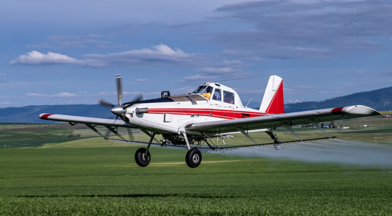 small low-flying plane spraying chemicals on crops