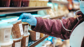 woman checking a food label in a grocery store