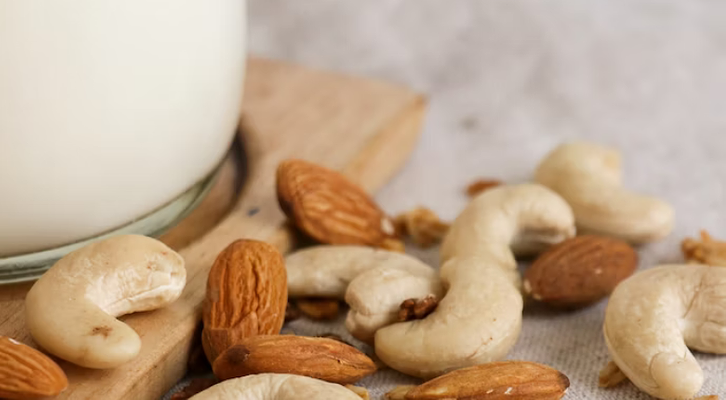 cashews and almonds next to jar of milk cashews and almonds next to jar of milk