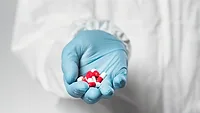gloved hand holding antibiotics gloved hand holding antibiotics