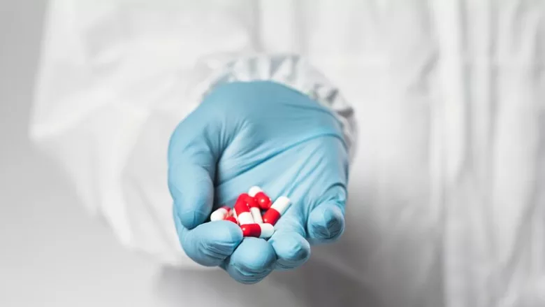 gloved hand holding antibiotics