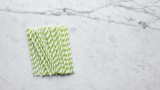green and white paper straws on marble surface