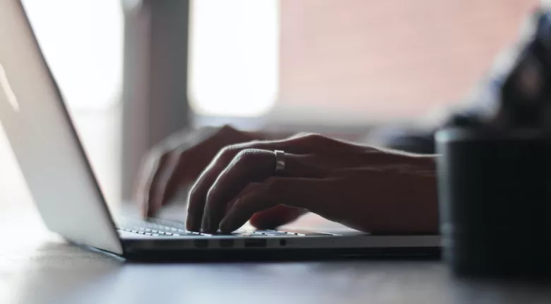 hands typing on laptop