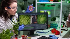 scientist holding up petri dish of meat